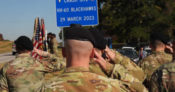 crash site sign with soldiers backs