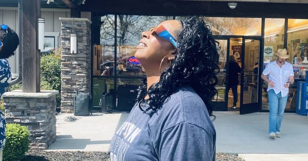 Amy Rogers, executive director of the Hopkinsville-Christian County Convention & Visitors Bureau, views the eclipse Monday from the front lawn of the visitor center. (Hoptown Chronicle photo by Jennifer P. Brown)