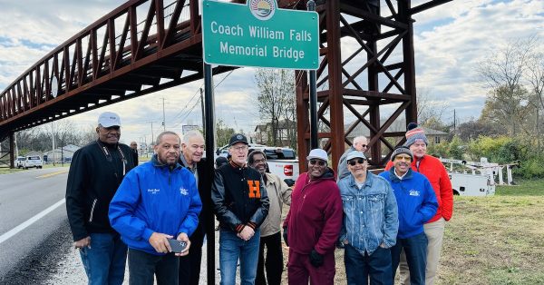 Former basketball players for Attucks and Hopkinsville high schools (from left) Jonathan White, Arnold Lynch, James Victor, Russell Hayes, Orlando Frame, Melvin Woodard, Kenneth Tompkins, Wendell Lynch and Mike Walker. pose during a dedication ceremony on Wednesday, Dec. 4, 2024, to name the Hopkinsville Greenway pedestrian bridge for their coach, the late William Falls. (Hoptown Chronicle photo by Jennifer P. Brown)