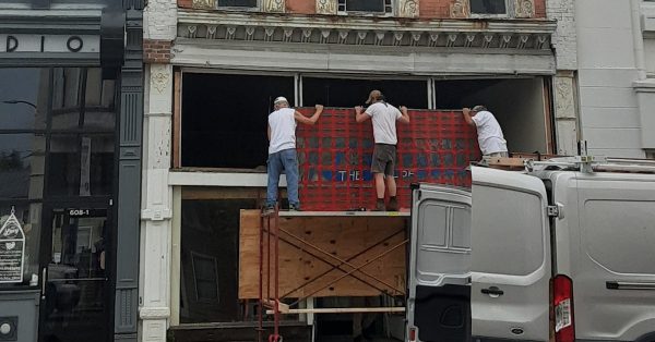 Workers on Wednesday remove the J.K. Hooser sign, originally installed in 1914, from the building at 610 S. Main St. (Photo provided by Fred Wilharm)