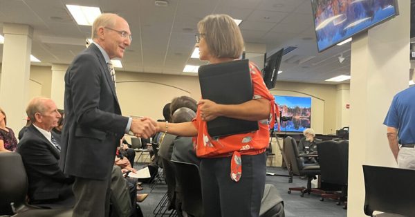 UK President Eli Capilouto, left, shakes hands with Sen. Lindsey Tichenor, ahead of an interim education committee meeting. (Kentucky Lantern photo by McKenna Horsley)