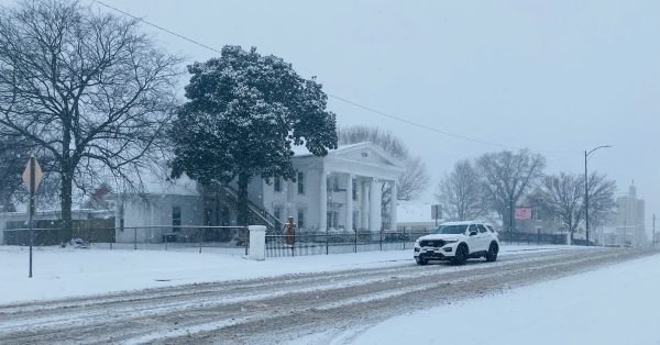 A car drives down Main Street as snow falls in Hopkinsville on Thursday, Jan. 6, 2022. (Photo by Jennifer P. Brown)