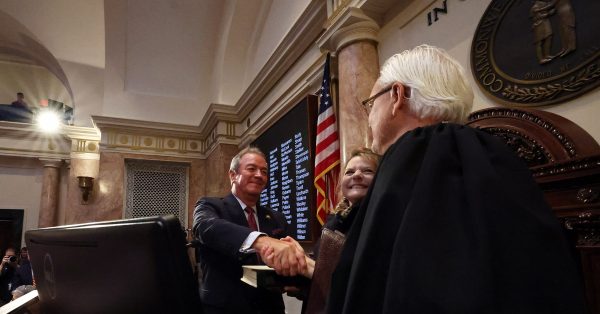 House Speaker David W. Osborne, R-Prospect, is congratulated by U.S. District Judge Gregory F. Van Tatenhove after his swearing in. The speaker’s wife, Loren Hebel Osborne, looks on. (LRC Public Information)