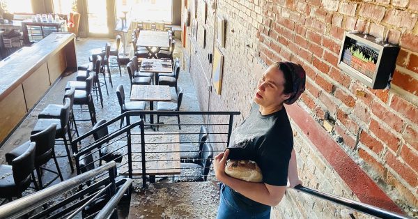 Heather Dawson looks downs to the main floor of The Mixer restaurant Saturday afternoon following a storm that tore out a portion of the building's third floor. She co-owns the restaurant with her husband, Graham Dawson. (Hoptown Chronicle photo by Jennifer P. Brown)