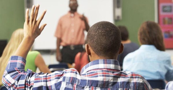 Male Pupil Raising Hand In Class