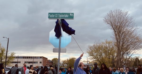 Dave Herndon, assistant director of Hopkinsville Public Works, pulls down a sign cover that the wind loosened on Wednesday, April 4, 2024, during a renaming ceremony.  (Hoptown Chronicle photo by Jennifer P. Brown)